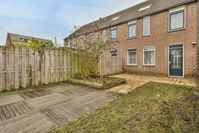 Footpath amidst houses against sky