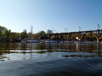 Sailboats on river against clear sky