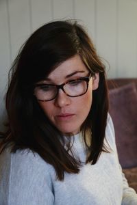 Close-up of young woman wearing eyeglasses at home