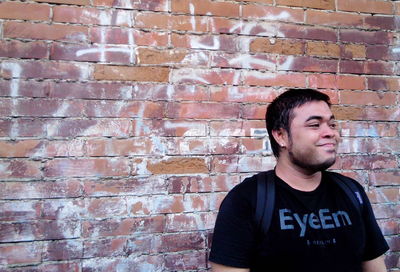 Portrait of young man standing on wall