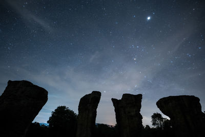 Low angle view of rocks against sky at night