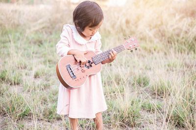 Boy playing guitar on field