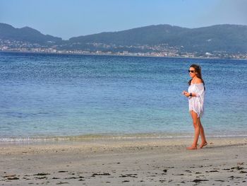 Full length of woman walking on shore at beach