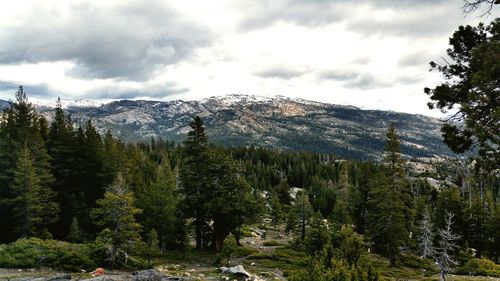 Scenic view of snow covered mountains against cloudy sky