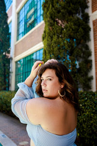 Portrait of beautiful young woman against plants