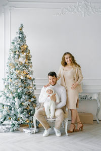 The concept of a family christmas. a beautiful family in light clothes is sitting 