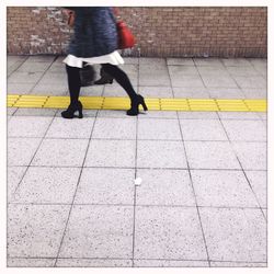 Low section of man walking on zebra crossing