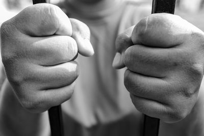 Midsection of person holding metal in prison