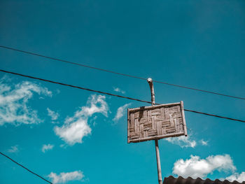 Low angle view of road sign against blue sky