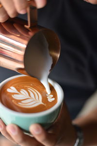 Close-up of barista making cappuccino at cafe