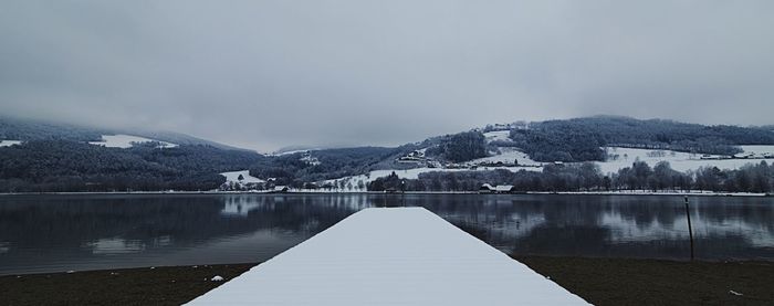 Scenic view of lake against sky during winter