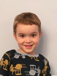 Portrait of smiling boy standing against wall