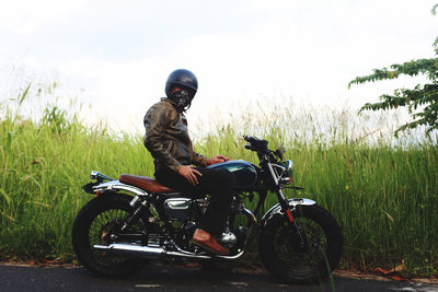 Man riding motor scooter on road