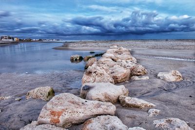 Rocks on sea shore against sky