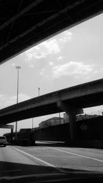 Road by bridge against sky in city