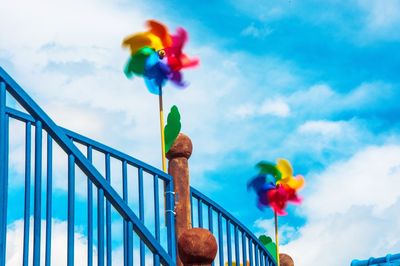 Low angle view of pinwheel against cloudy sky