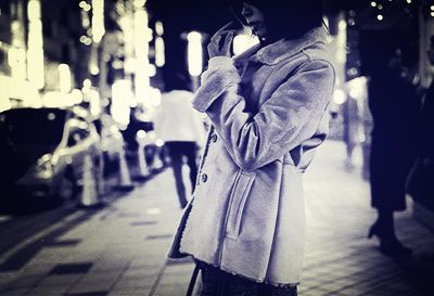 Woman walking on road at night
