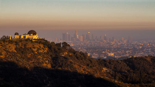 Buildings in city during sunset