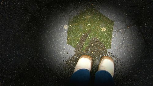 Low section of woman standing on wet floor during rainy season