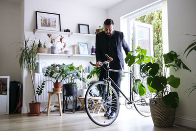 Businessman entering with bicycle at home