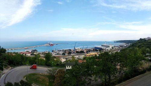 High angle view of city by sea against sky