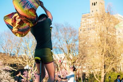 Midsection of woman holding umbrella against sky