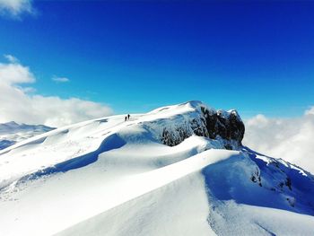 Scenic view of snowcapped mountains against blue sky