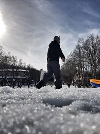 Man skiing on snowcapped mountain against sky