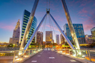 Illuminated bridge over river in city at night