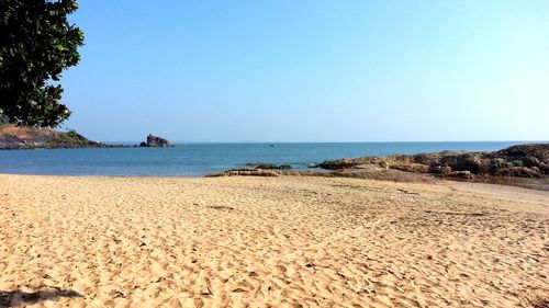 Scenic view of beach against clear blue sky