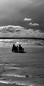 Scenic view of beach against cloudy sky