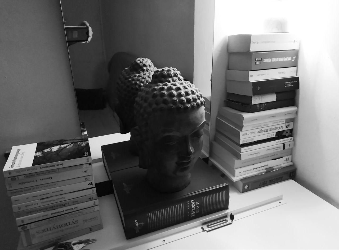 STACK OF BOOKS ON TABLE IN SHELF