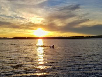 Silhouette boat sailing on sea against sky during sunset