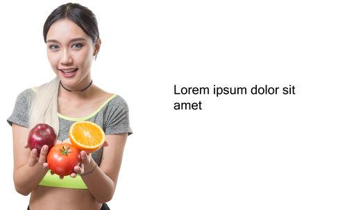 Portrait of smiling man holding fruit against white background