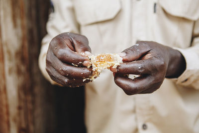 Midsection of man holding beehive