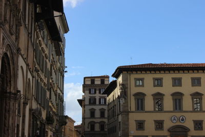 Low angle view of buildings in town against sky
