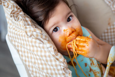 Close-up portrait of cute baby eating food