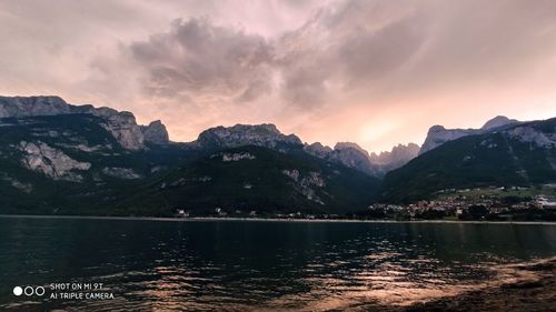 Scenic view of lake by mountains against sky