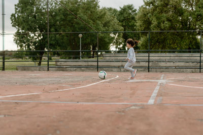 Girl playing soccer in ground