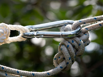 Close-up of rope tied on metal chain