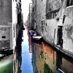 Boats in canal along buildings