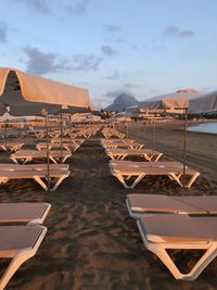 Chairs on beach against sky