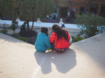 Rear view of couple sitting outdoors