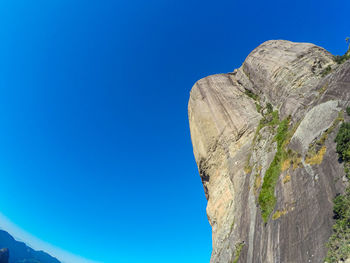 Low angle view of rock formation against clear blue sky