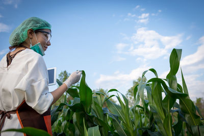 Woman standing in farm against sky