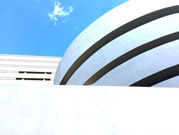 Low angle view of modern building against blue sky