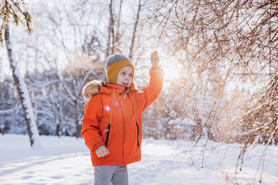 Portrait of young woman standing in snow