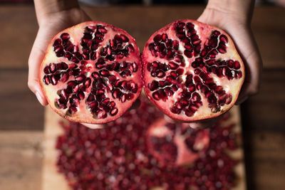 Cropped hands of person holding pomegranates