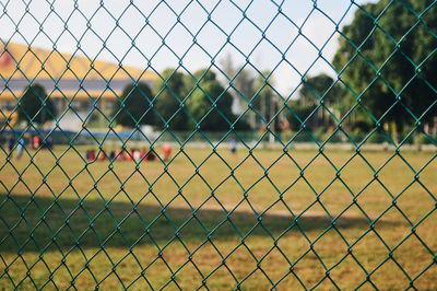 People on soccer field seen through chainlink fence