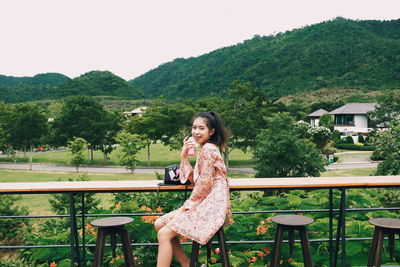 Portrait of a smiling young woman against trees